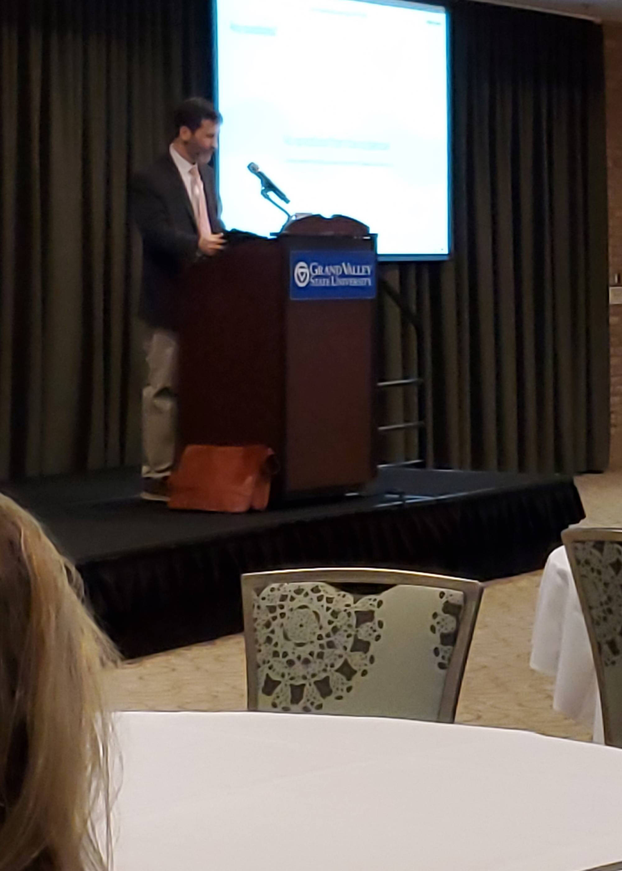 Sean Lancaster on the podium, giving the keynote at the GVSU Assessment Conference 2025